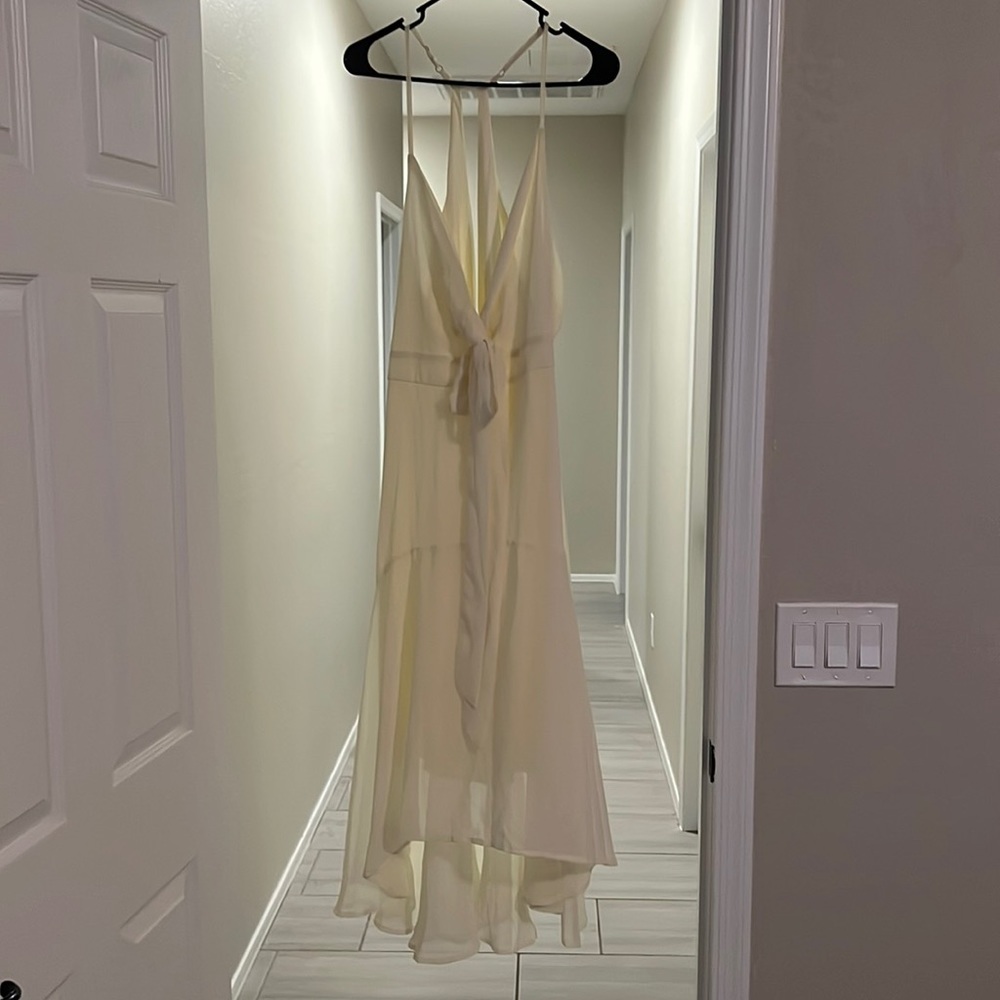 Yellow semi formal dress. Cutout in the back and the front. V-neck with tie.
